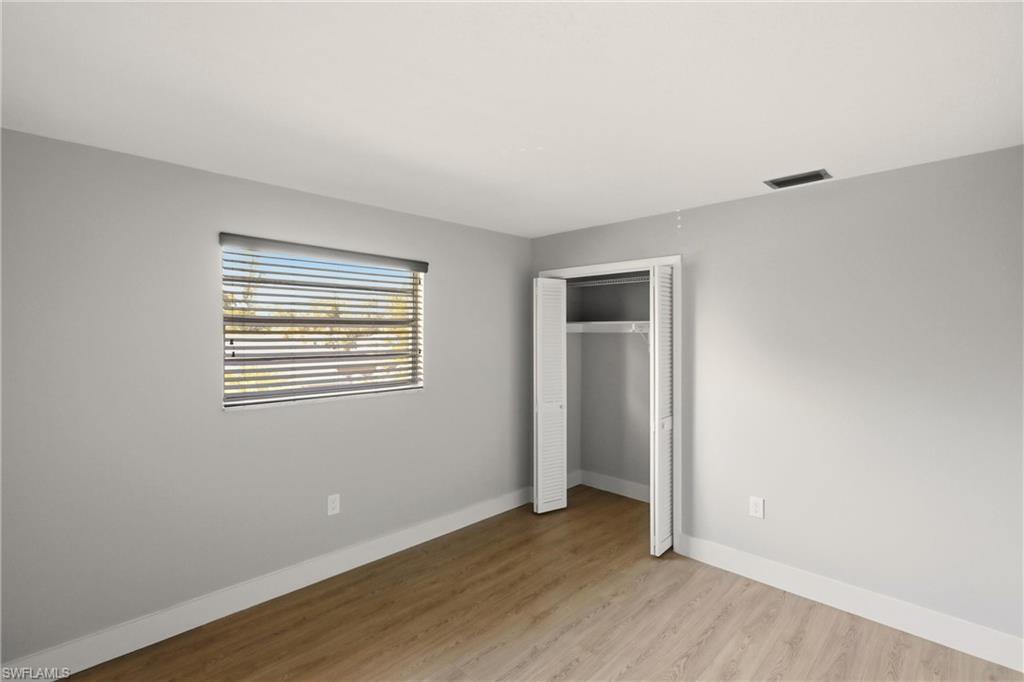 3325 Airport Road North, Unit S8 Naples, FL 34105 - Photo 13 of 33 a view of an empty room with wooden floor and a window