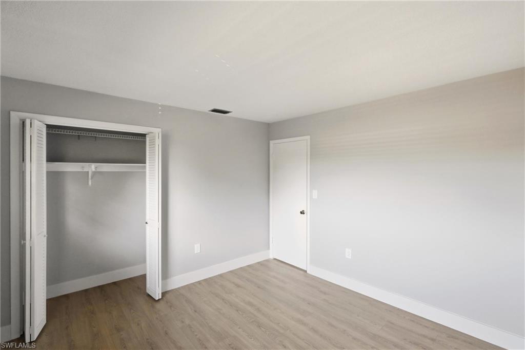 3325 Airport Road North, Unit S8 Naples, FL 34105 - Photo 14 of 33 an empty room with wooden floor and closet