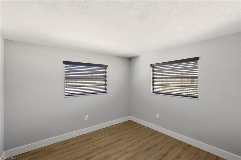 3325 Airport Road North, Unit S8 Naples, FL 34105 - Photo 17 of 33 a view of an empty room with wooden floor and a window