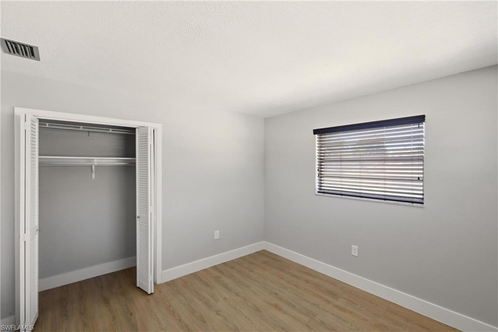 3325 Airport Road North, Unit S8 Naples, FL 34105 - Photo 18 of 33 a view of an empty room with wooden floor and a window