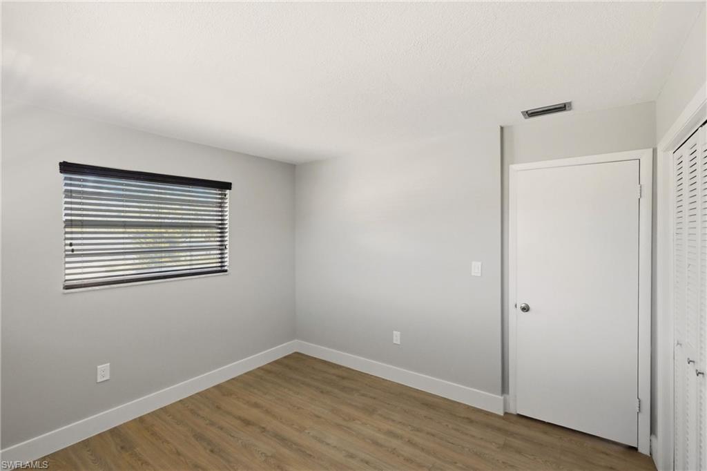 3325 Airport Road North, Unit S8 Naples, FL 34105 - Photo 19 of 33 a view of an empty room with wooden floor and a window