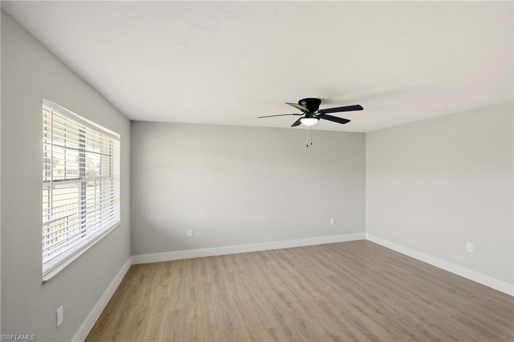3325 Airport Road North, Unit S8 Naples, FL 34105 - Photo 5 of 33 wooden floor in an empty room with a window