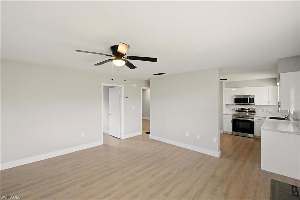 3325 Airport Road North, Unit S8 Naples, FL 34105 - Photo 7 of 33 a view of a kitchen with wooden floor and a ceiling fan