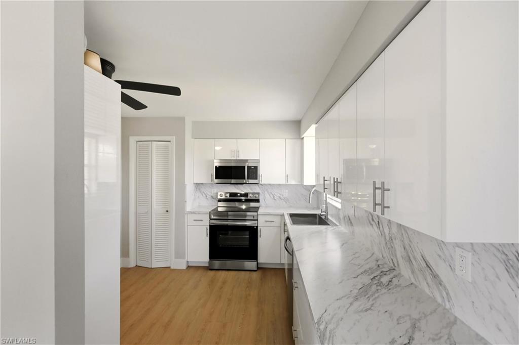 3325 Airport Road North, Unit S8 Naples, FL 34105 - Photo 8 of 33 a kitchen with stainless steel appliances granite countertop a sink stove and refrigerator