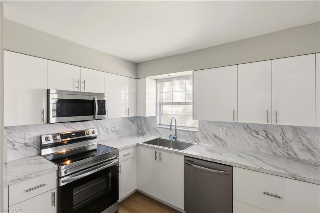 3325 Airport Road North, Unit S8 Naples, FL 34105 - Photo 9 of 33 a kitchen with a sink and a stove top oven