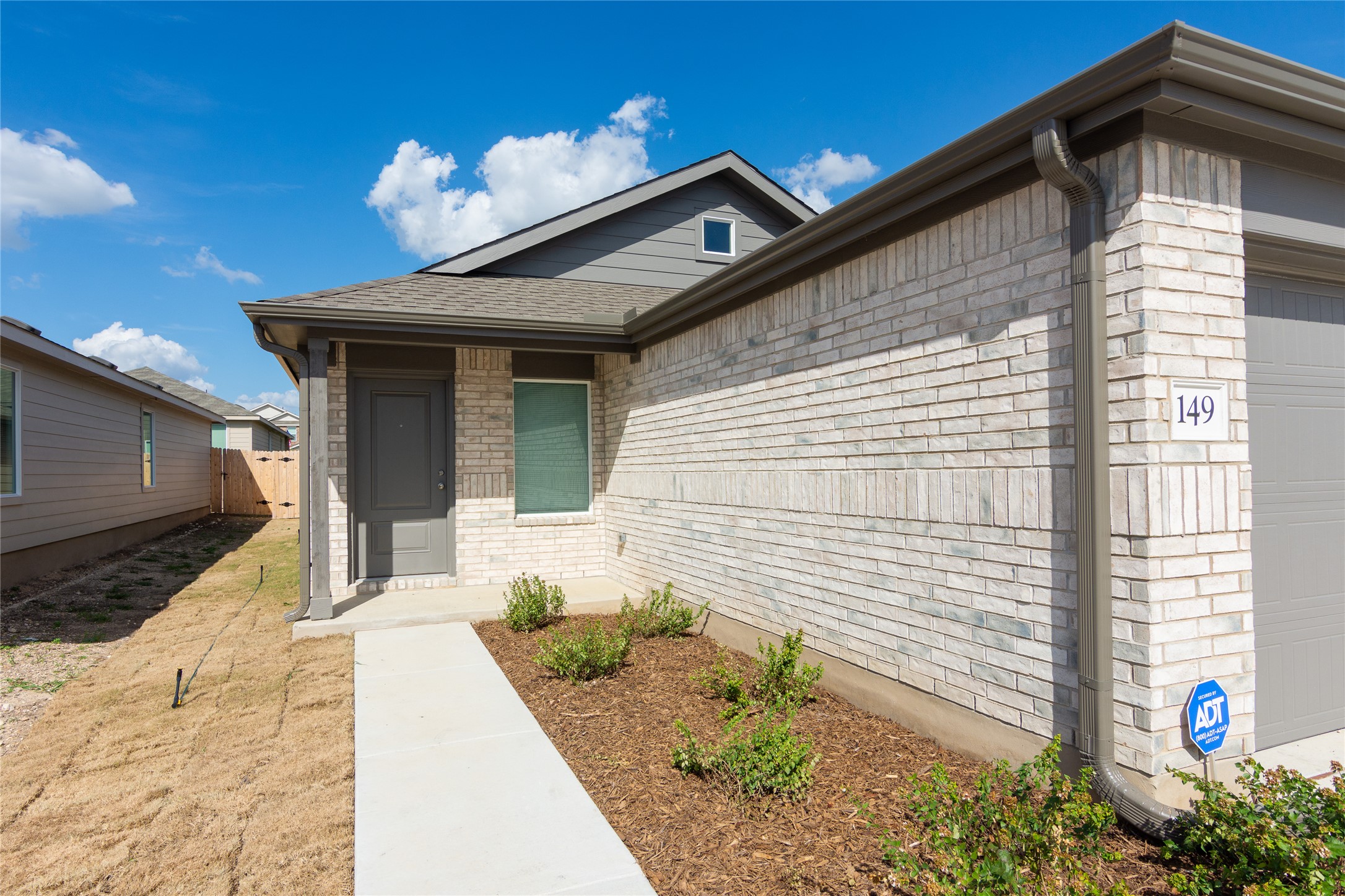149 Star Packer Lane Jarrell, TX 76537 - Photo 4 of 30 Discover a charming modern dwelling featuring light-toned brickwork and inviting porch columns.