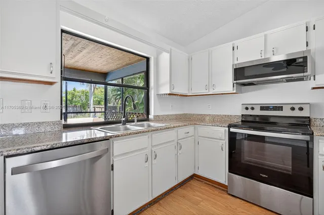 a kitchen with appliances cabinets and a sink