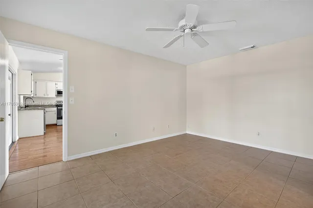 wooden floor in an empty room with a kitchen