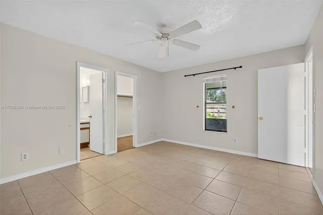 an empty room with fan and windows