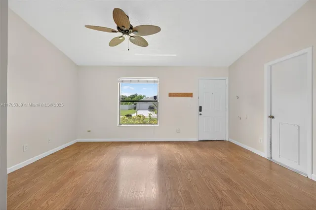 a view of room with hardwood floor and ceiling fan