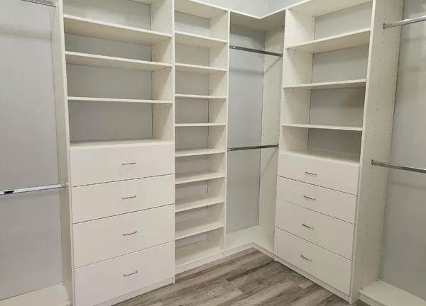 a view of walk in closet with empty racks