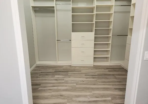 a view of walk in closet with empty racks