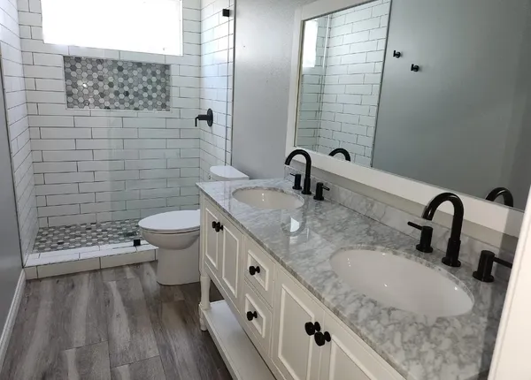 a bathroom with a granite countertop sink a toilet and shower