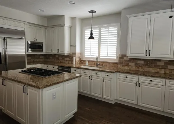 a kitchen with stainless steel appliances granite countertop a sink stove and cabinets