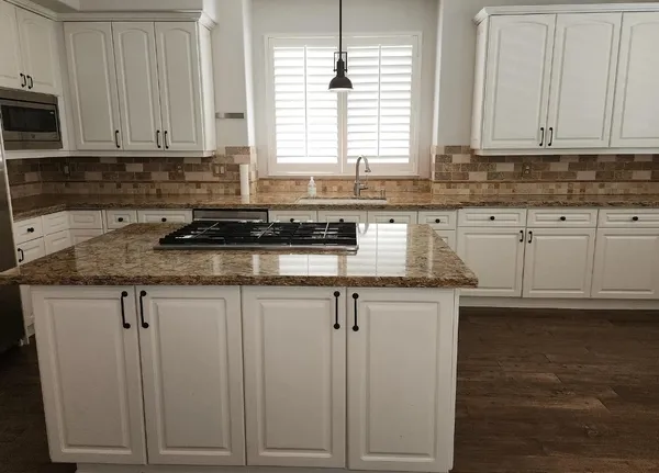 a kitchen with granite countertop white cabinets and a counter top space