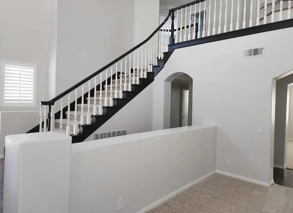 a view of staircase with wooden floor and white walls
