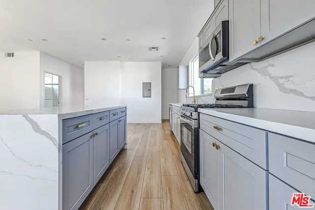 a kitchen with stainless steel appliances granite countertop a stove a sink and a refrigerator