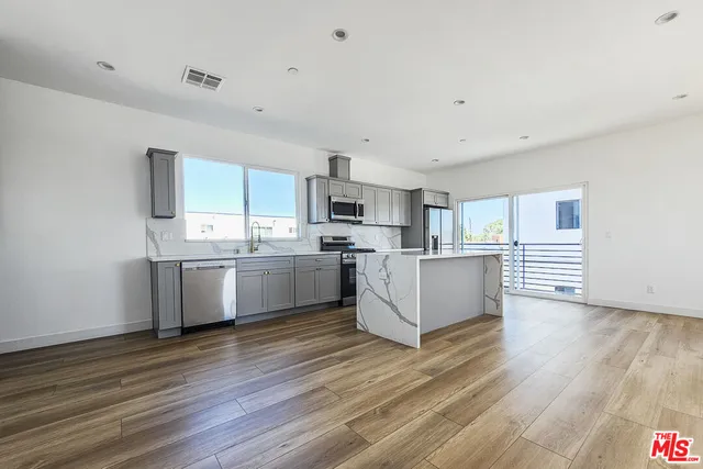a kitchen with stainless steel appliances a refrigerator sink and cabinets