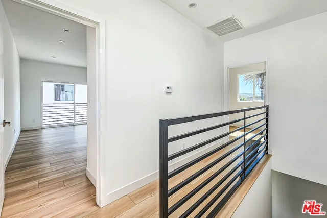 a view of a hallway with wooden floor and staircase