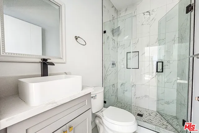 a view of a room with wooden floor and a bathroom