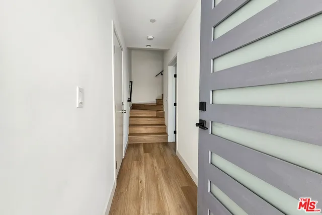 a view of a hallway with wooden floor and staircase