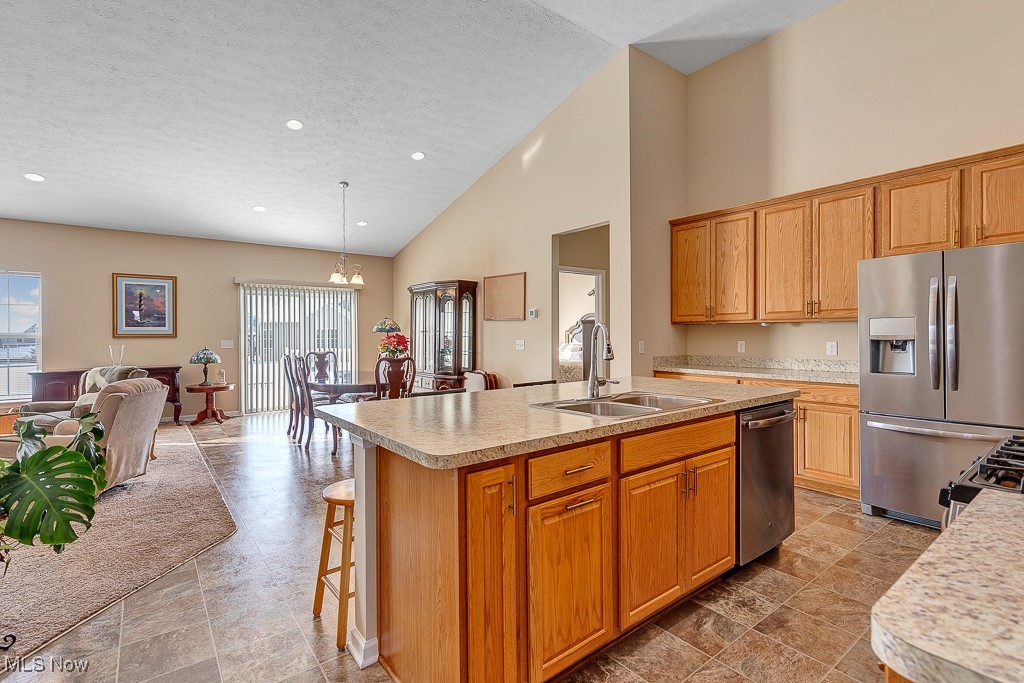 37289 Sandy Ridge Drive North Ridgeville, OH 44039 - Photo 4 of 21 Kitchen featuring pendant lighting, sink, a high ceiling, appliances with stainless steel finishes, and an island with sink
