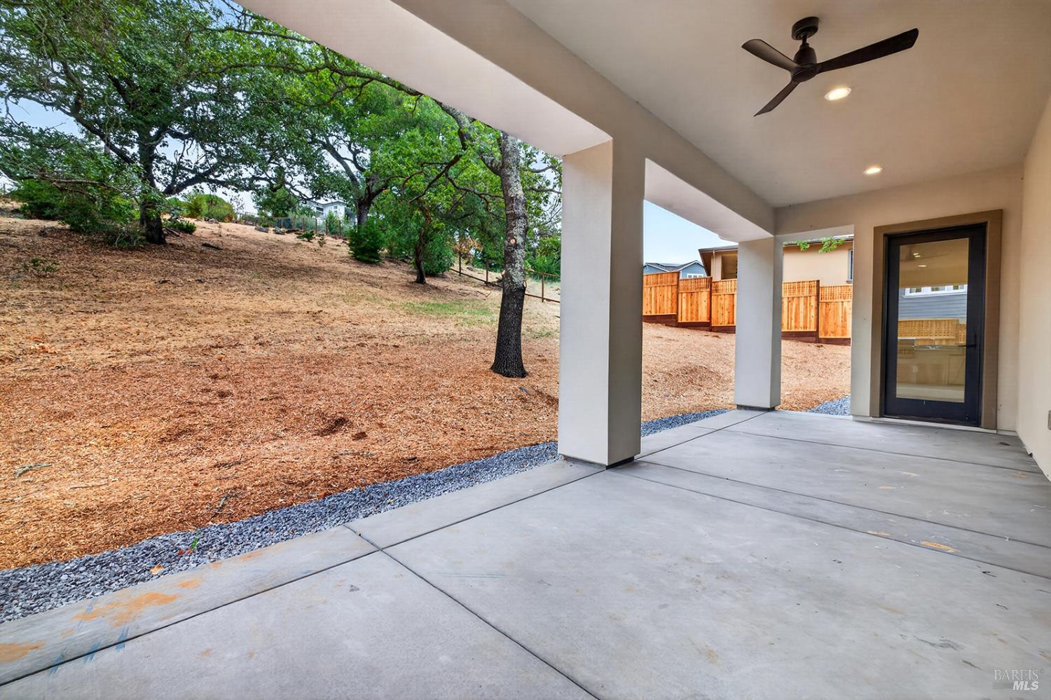 1913 Carlile Place Santa Rosa, CA 95403 - Photo 12 of 60 As we step outside of the great room, you see this covered loggia and the view looking back on the 1/2 acre plus lot of this amazing home. The door to the right leads to the main level primary suite, one of two this home offers with the other one located on the upper level.