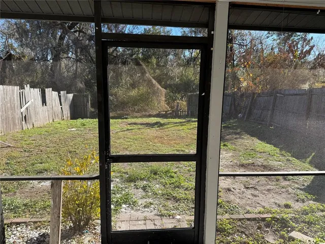 a view of a room with a large window and wooden floor