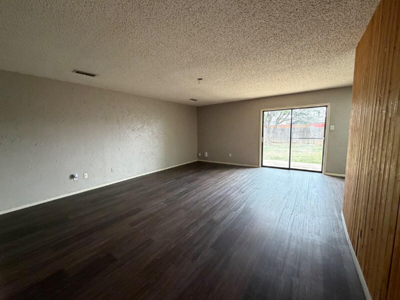 6306 28th Street Lubbock, TX 79407 - Photo 2 of 9 an empty room with wooden floor and windows
