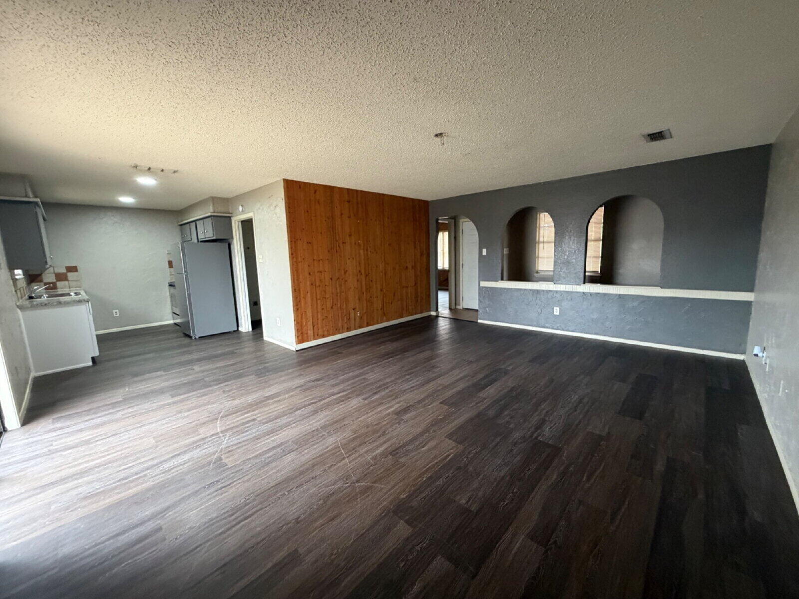6306 28th Street Lubbock, TX 79407 - Photo 3 of 9 an empty room with wooden floor and windows