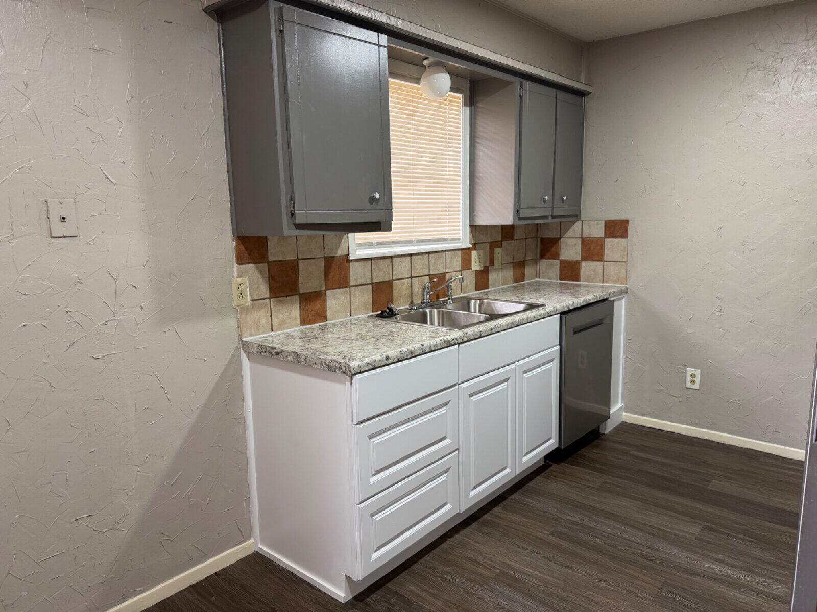 6306 28th Street Lubbock, TX 79407 - Photo 4 of 9 a kitchen with a sink cabinets and wooden floor