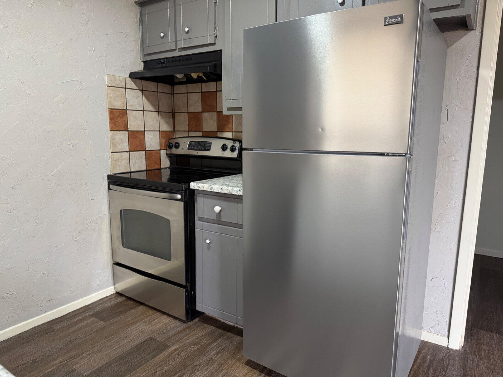 6306 28th Street Lubbock, TX 79407 - Photo 5 of 9 a kitchen with metallic refrigerator and a stove
