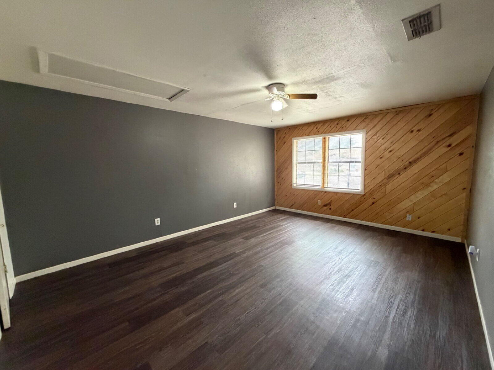 6306 28th Street Lubbock, TX 79407 - Photo 6 of 9 an empty room with wooden floor and windows
