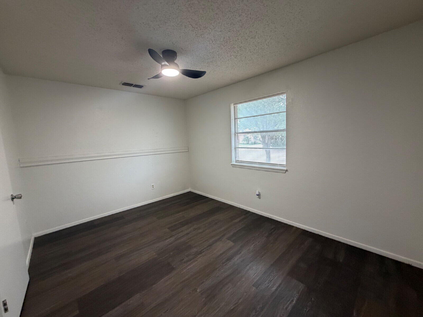 6306 28th Street Lubbock, TX 79407 - Photo 7 of 9 an empty room with wooden floor and windows