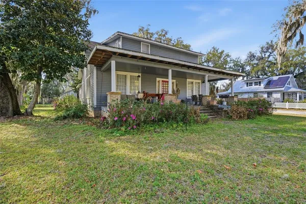 a view of a house with a big yard and potted plants