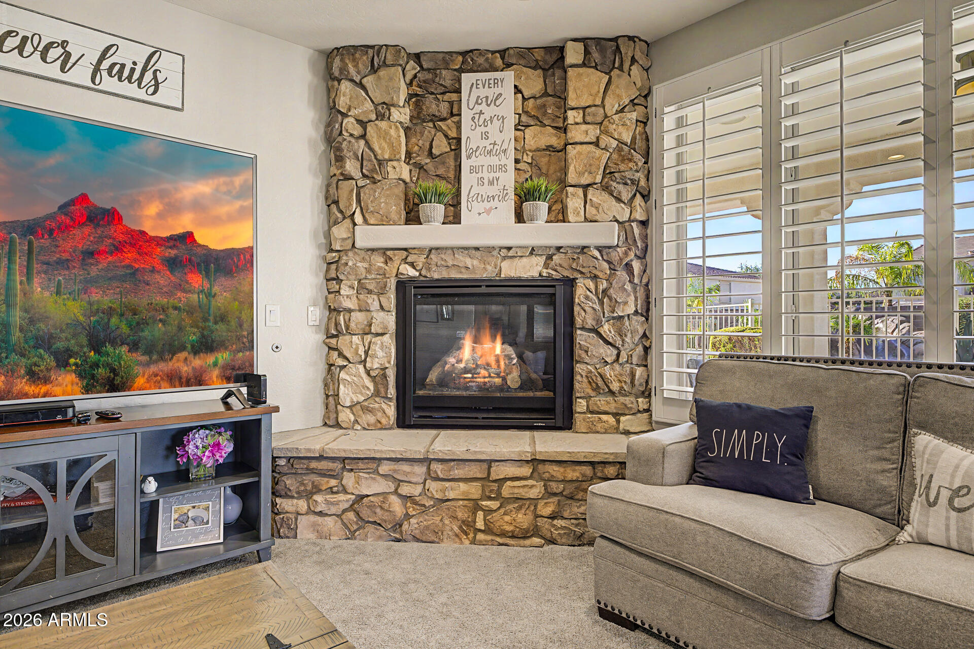 13058 West Lowden Road Peoria, AZ 85383 - Photo 25 of 122 a living room with furniture a fireplace and a floor to ceiling window