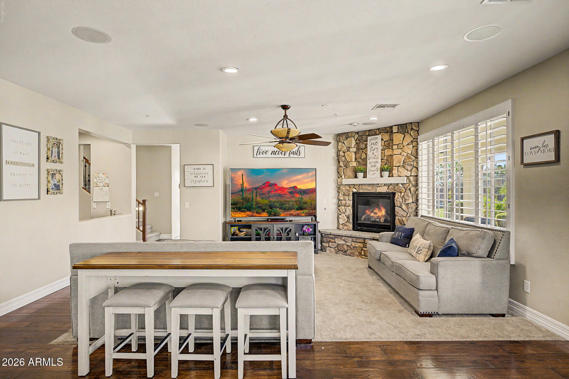 13058 West Lowden Road Peoria, AZ 85383 - Photo 26 of 122 a living room with furniture a flat screen tv and a fireplace