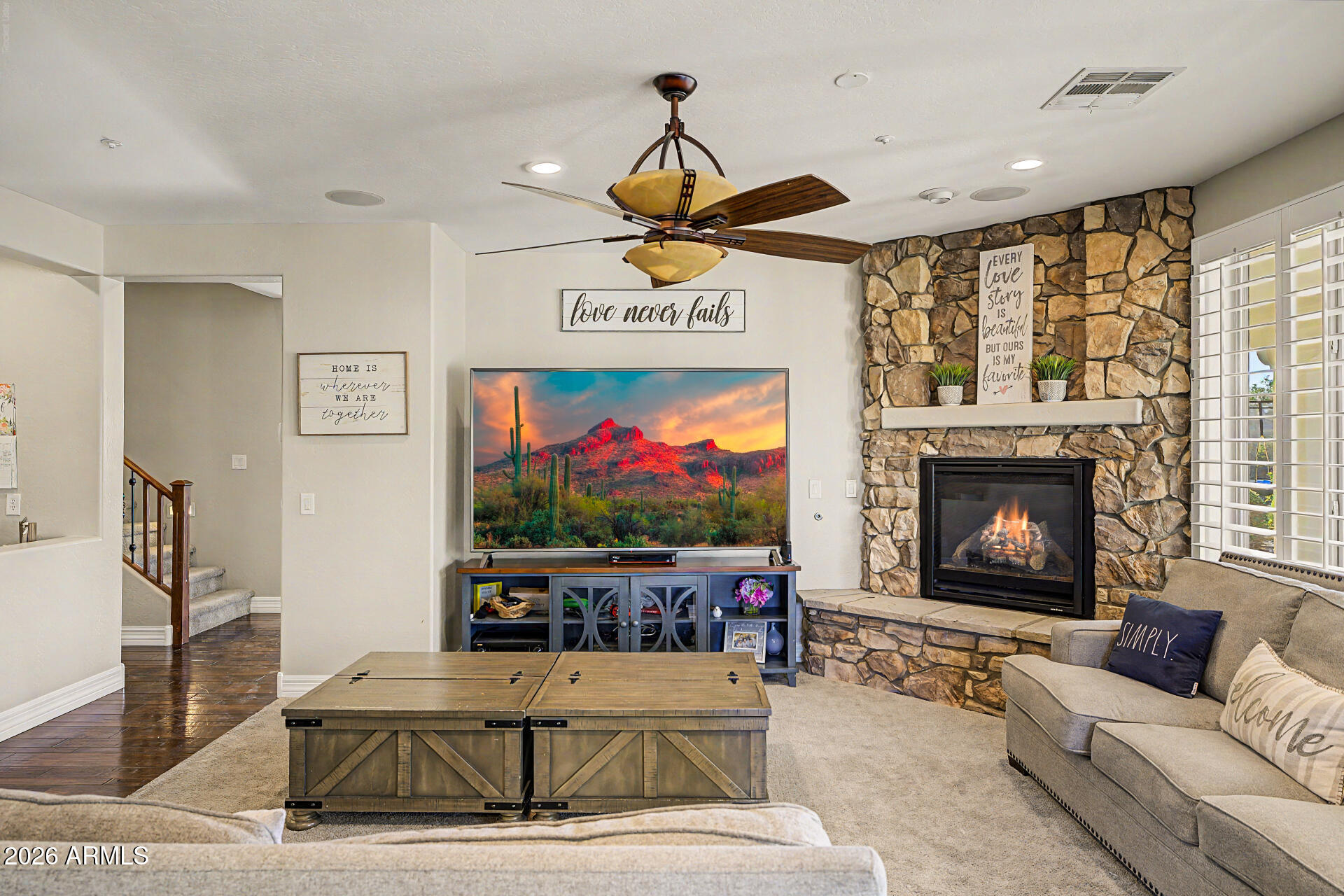 13058 West Lowden Road Peoria, AZ 85383 - Photo 28 of 122 a living room with furniture a flat screen tv and a fireplace