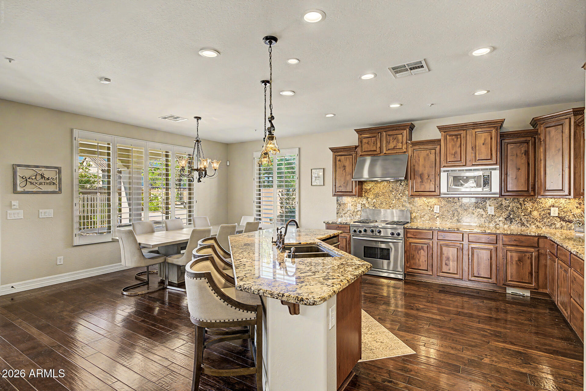 13058 West Lowden Road Peoria, AZ 85383 - Photo 31 of 122 a kitchen with stainless steel appliances granite countertop a stove and cabinets