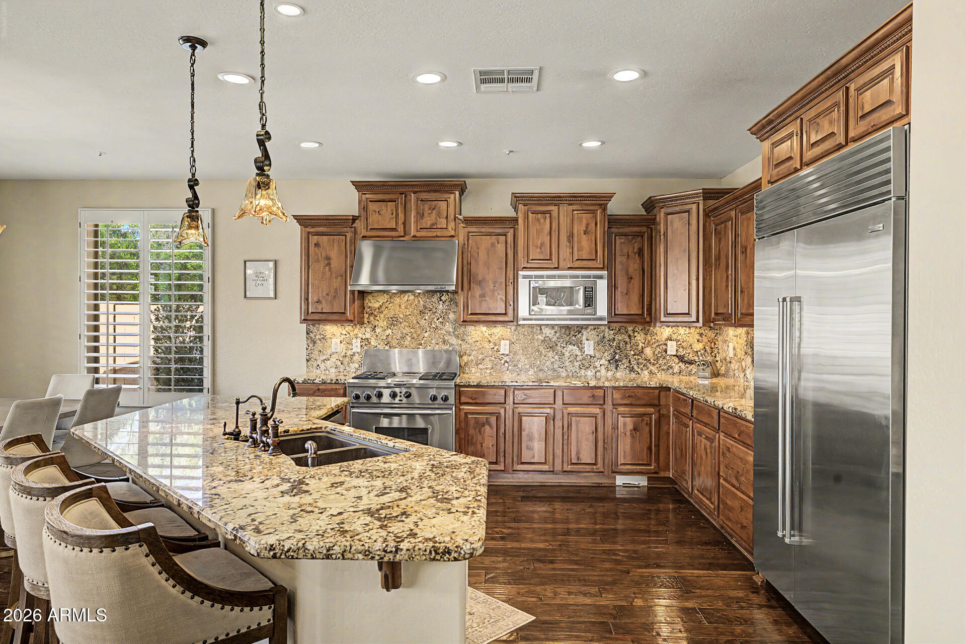13058 West Lowden Road Peoria, AZ 85383 - Photo 32 of 122 a kitchen with stainless steel appliances granite countertop a sink stove and refrigerator