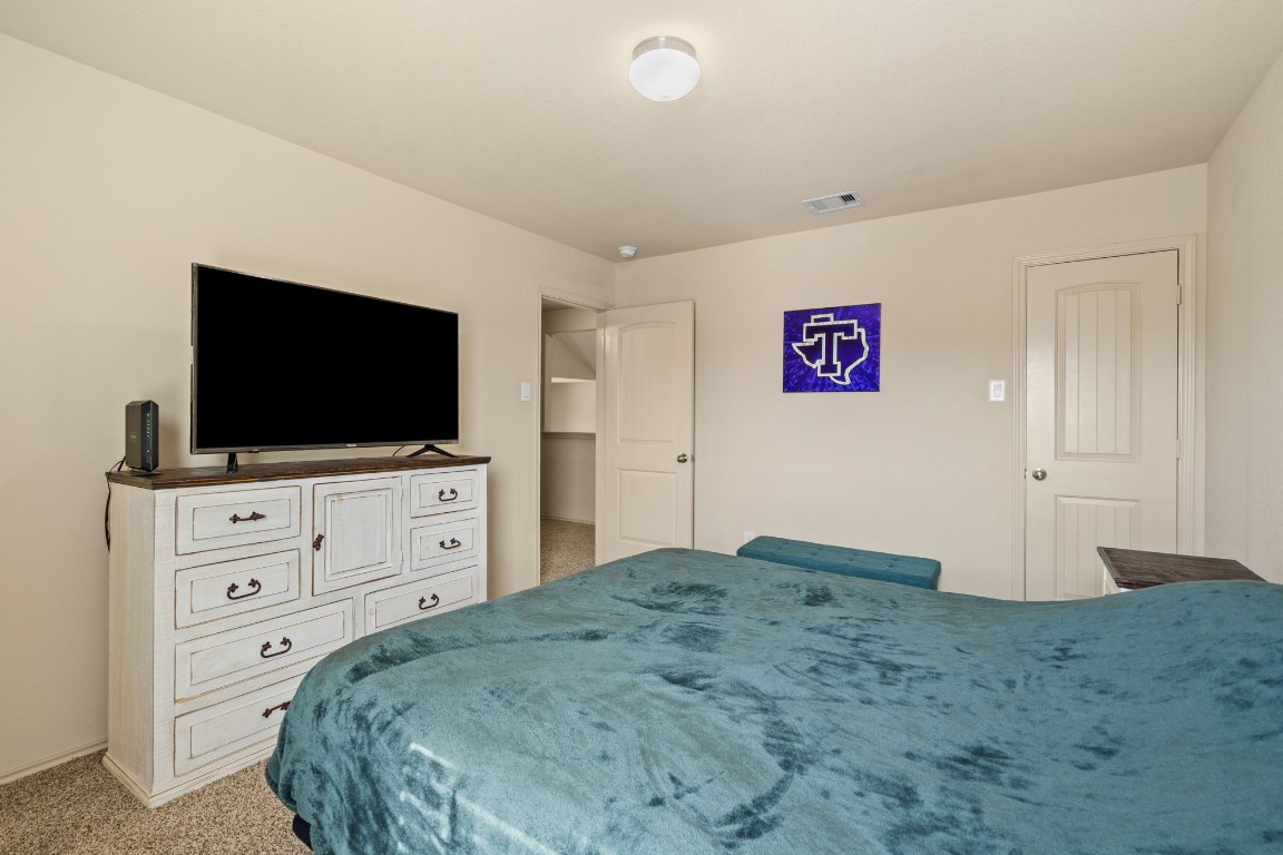2034 Harmon Park Court Spring, TX 77373 - Photo 24 of 31 a bedroom with a bed and a flat screen tv in dresser