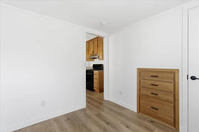 a view of an empty room with wooden floor