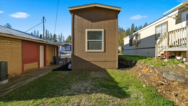 a yellow house with tall trees in front of it