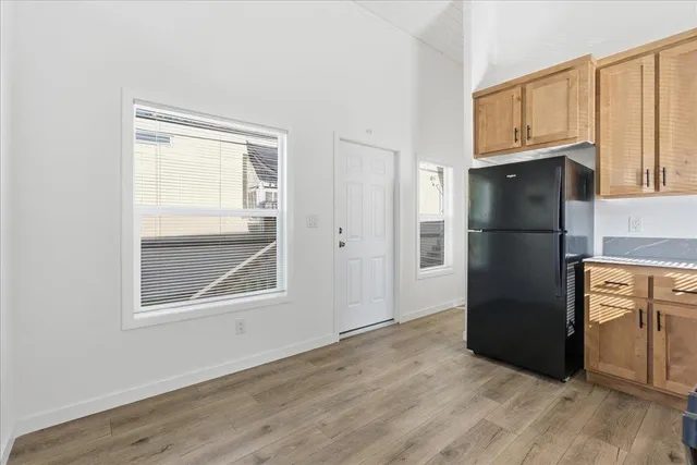 a view of kitchen with wooden cabinet and refrigerator