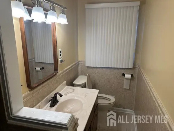 a white toilet sitting next to a sink and vanity