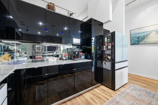 a kitchen with stainless steel appliances granite countertop a refrigerator and a sink