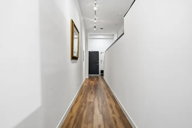 a view of a hallway with wooden floor and staircase