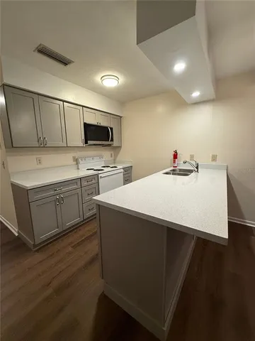 a kitchen with a sink cabinets and wooden floor