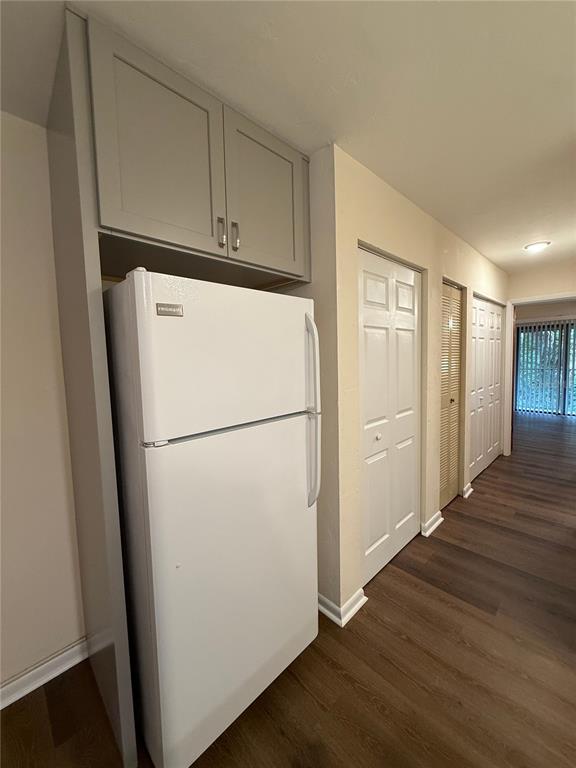 1923 Northwest 23rd Boulevard, Unit 224 Gainesville, FL 32605 - Photo 7 of 20 a white refrigerator freezer and a wooden floor in a room