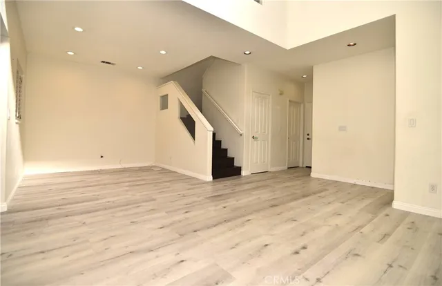 an empty room with wooden floor and entryway